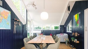 A dining area with a wooden table and chairs, a globe, and a map on the wall. - Captivating Holiday Home in Ulfborg near Sea (Ulfborg)