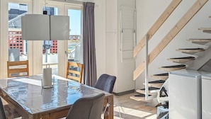 Eine moderne Küche mit Essbereich, einer Treppe und Blick auf die Stadt.