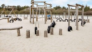 Ein Outdoor-Fitnessbereich mit Holzkonstruktionen und Reifen.