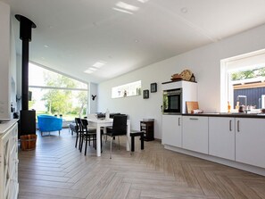 A modern kitchen with white cabinets, a built-in oven, and a large window. - Woodland Holiday Home in Jægerspris with Hot Tub (Jægerspris)