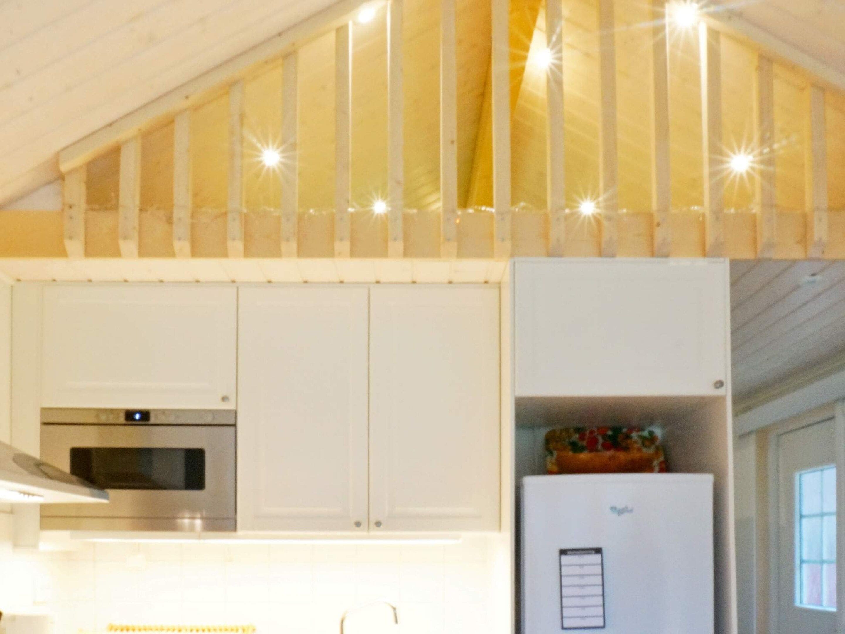 A kitchen with white cabinets, a stainless steel oven, and a white refrigerator.