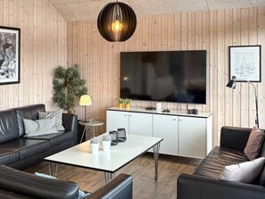 A modern living room with a sofa, a coffee table, a TV, and a cabinet.