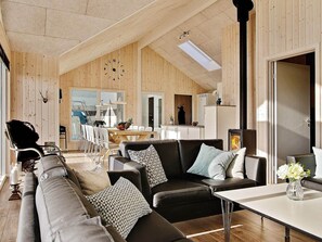 Un vaste espace de vie avec un décor intérieur en bois, une table à manger et une cheminée.