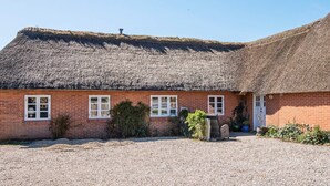 A thatched-roof building with a gravel driveway and a small garden area. - 3 Person Holiday Home in Høll Børkop (Borkop)