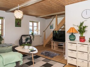 A cozy living room with a sofa, a coffee table, a TV, and a staircase. - 3 Person Holiday Home in Høll Børkop (Borkop)