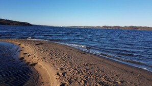 A beach with clear blue water, a sandy shore, and a distant bridge. - 3 Person Holiday Home in Høll Børkop (Borkop)