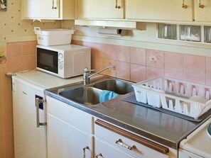 A kitchen with a sink, a microwave, and cabinets. - 4 Person Holiday Home in Hastveda (Hästveda)