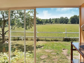A room with a large sliding glass door leading to a grassy field with a white fence. - 4 Person Holiday Home in Hastveda (Hästveda)