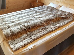 En säng med ett stort, mjukt och strukturerat täcke.