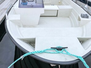 En båt med en vit inredning, en kontrollpanel och ett blått rep som är fastknutet i en knape.