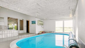 A swimming pool with a marble edge, a view of the outdoors, and a ceiling with recessed lighting. - 4 Star Holiday Home in Hals (Hals)