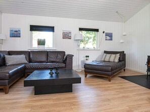 A living room with a brown leather sofa, a smaller sofa, a coffee table, and a fireplace.