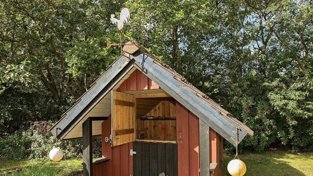 A small wooden structure with a sloped roof, a door, and a window. - 6 Person Holiday Home in NÃ¸rre Nebel (Norre Nebel)