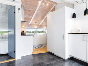 Una cocina moderna con armarios blancos, encimera negra y vistas al exterior.