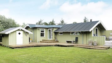 A small, single-story building with a porch and a covered outdoor seating area.