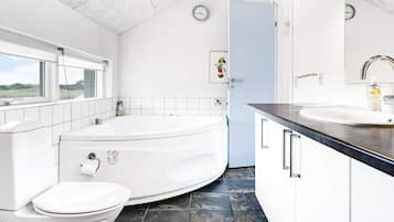 A modern bathroom with a toilet, a bathtub, and a sink.