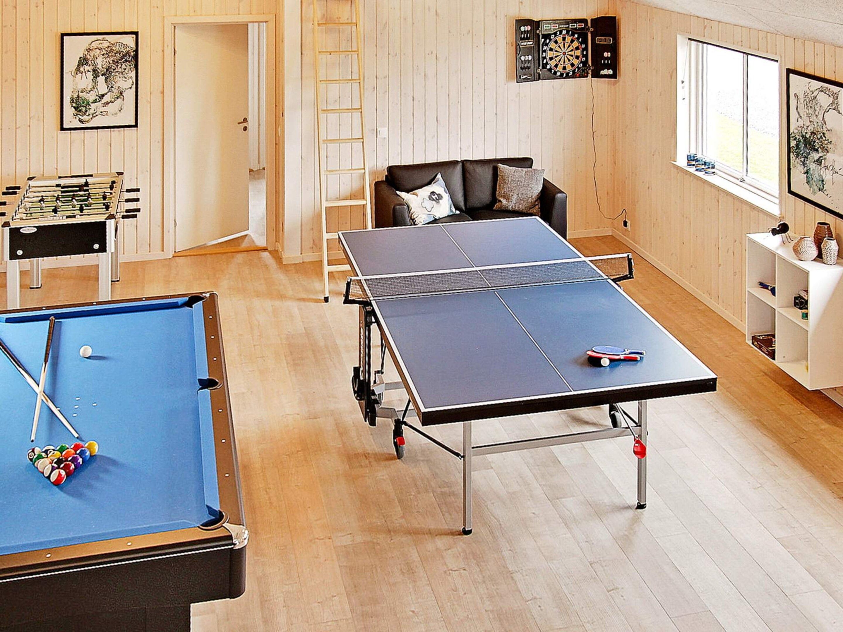 Une pièce équipée d’une table de billard, d’un baby-foot et d’une table de ping-pong.