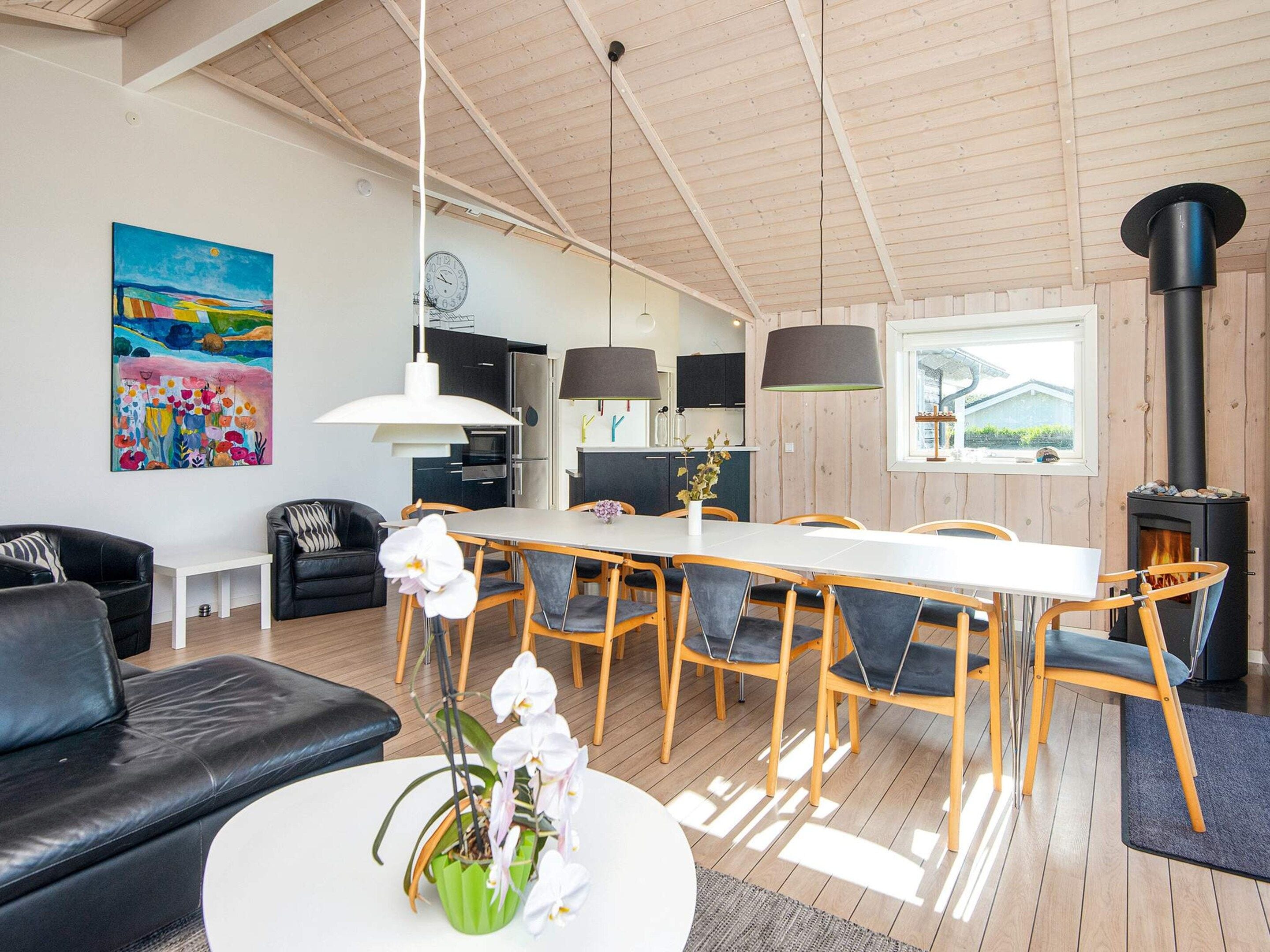 Un espace de vie moderne comprenant un coin repas, une cuisine et une cheminée.