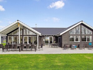 Un bâtiment à deux étages doté d’un patio aménagé avec du mobilier d’extérieur.
