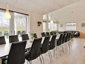Ein Konferenzraum mit einem langen Tisch, schwarzen Stühlen und Pendelleuchten.
