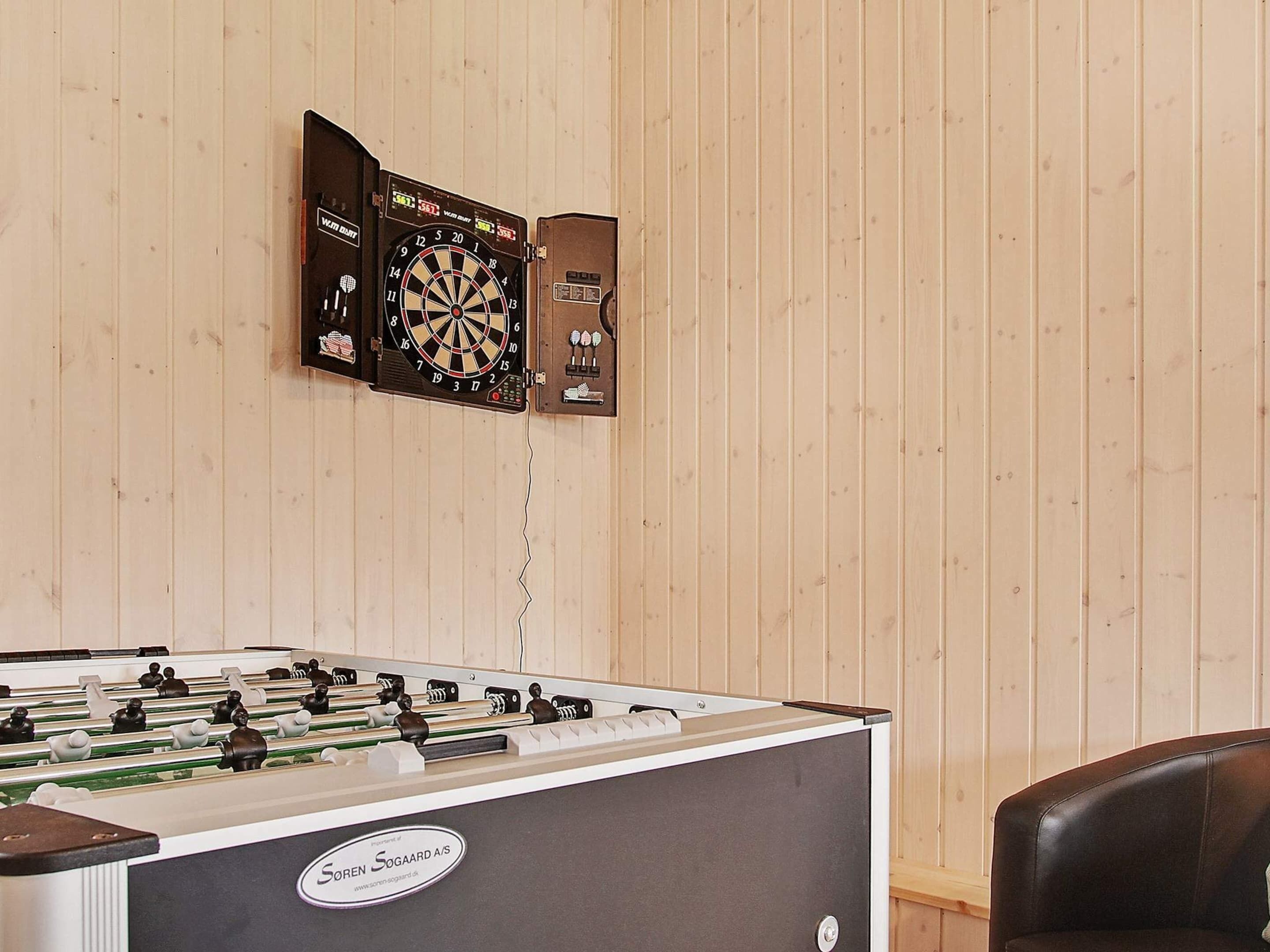 Et bordtennisbord med et dartskive og to dartskiver på væggen.
