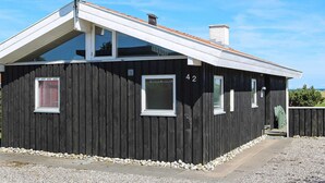 A black wooden building with the number 42, a satellite dish, and a chimney. - 4 Star Holiday Home in Hadsund (Hadsund)