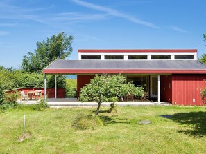 A red building with a flat roof and a covered porch. - 8 Person Holiday Home in Asnaes (Asnaes)