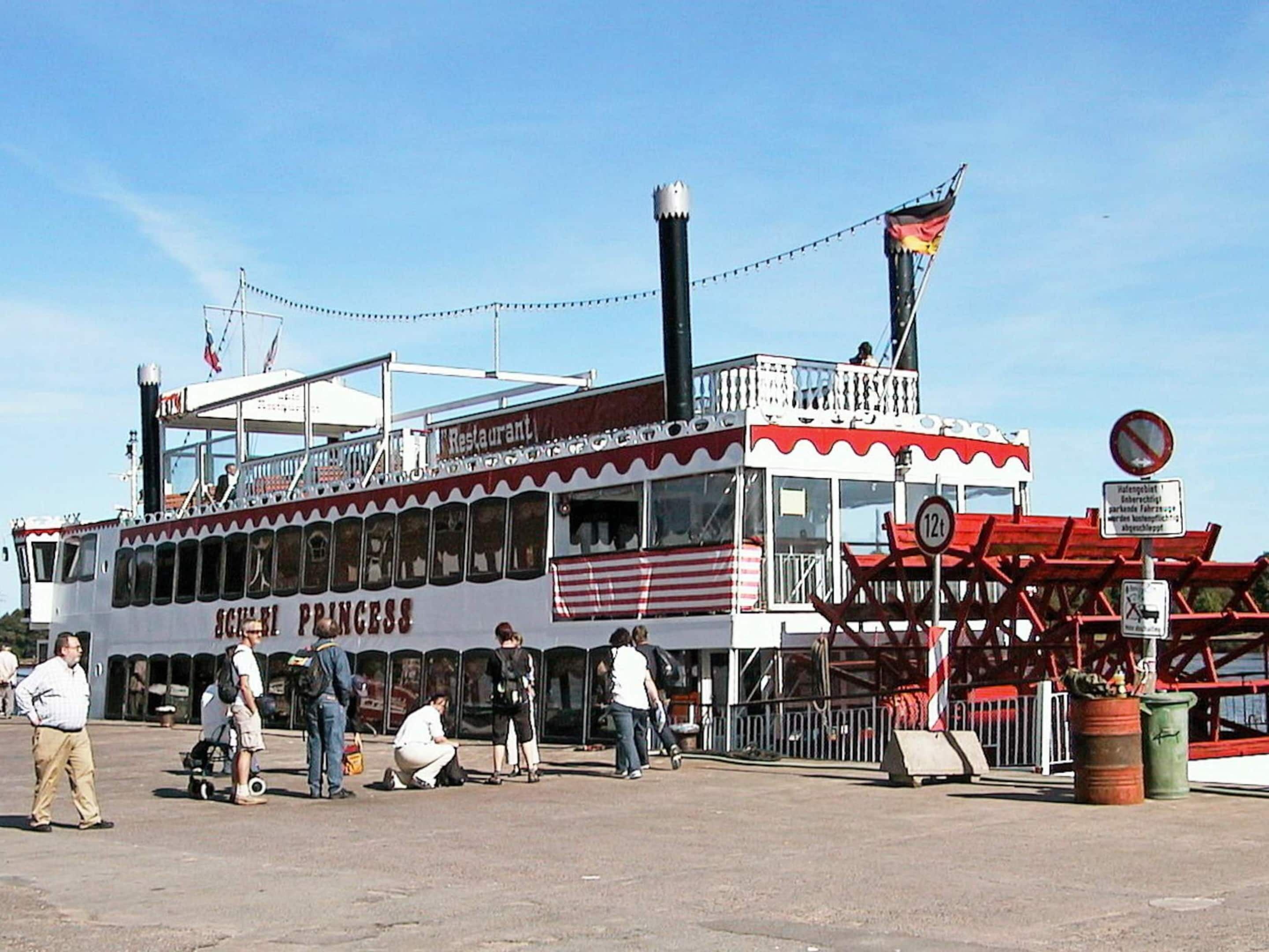 A steamboat with a restaurant named 'Sailor Princess' docked at a pier.