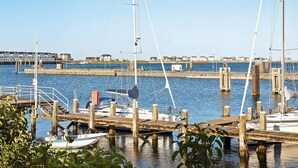 A marina with boats docked at wooden piers, a clear sky, and buildings in the background. - Holiday Home in Kappeln (Kappeln)