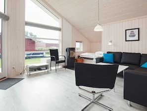 Ein modernes Interieur mit Sofa, Sessel, kleinem Tisch und Bett.