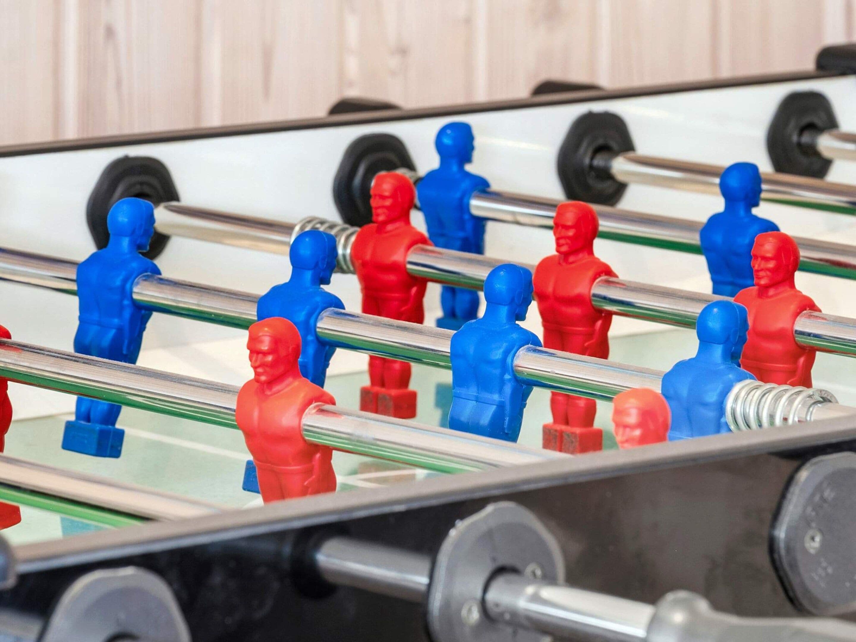 Ein Kicker mit roten und blauen Spielfiguren.