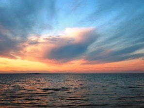 A sunset over a calm sea with a clear horizon.