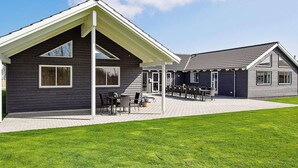 A modern building with a covered patio area, a separate dining section, and a well-maintained lawn. - Holiday Home in Kappeln (Kappeln)