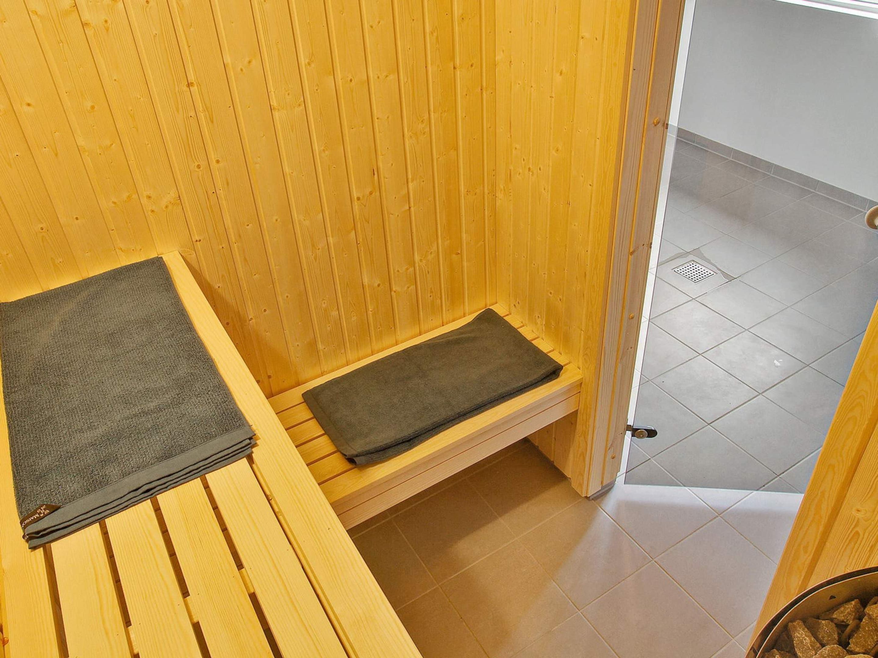 A wooden sauna room with a bench and a step.