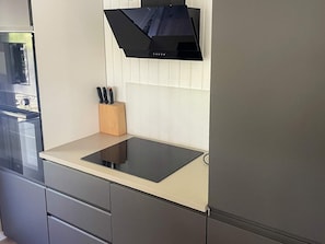 A kitchen with a built-in stove, a knife block, and a modern design.