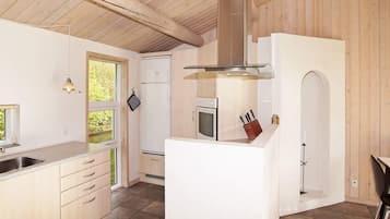 Una cocina moderna con una isla central, armarios de madera y una campana extractora de acero inoxidable.