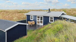 A coastal house with a deck, a covered outdoor seating area, and a view of the dunes. - 4 Star Holiday Home in Albaek (Aalbaek)