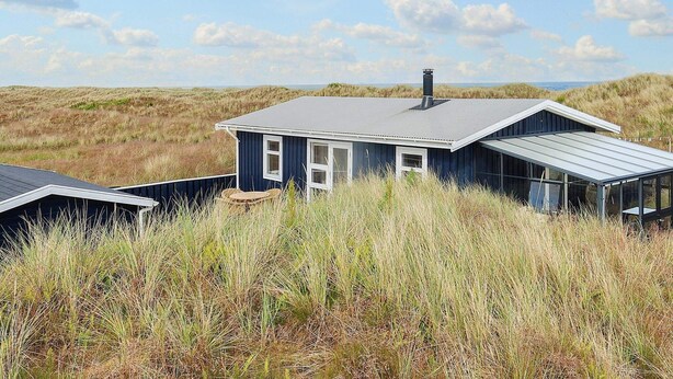 A coastal house with a dark blue exterior, a grey roof, and a glass conservatory. - 4 Star Holiday Home in Albaek (Aalbaek)