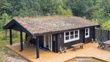 A cabin with a deck, a covered porch, and a number '2' on the side.