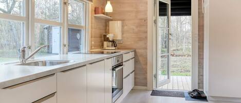 Una cocina moderna con un amplio ventanal, una cafetera y un horno empotrado.