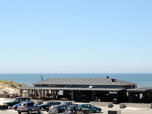 A building with a sign 'ISKIOSK' and a parking area with several cars. - 4 Star Holiday Home in Henne (Henne)