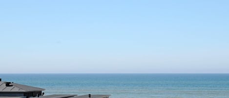 A beachside facility with a parking area and a view of the ocean.