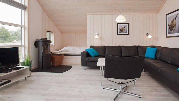 Een moderne woonkamer met een bank, een televisie en een open haard.