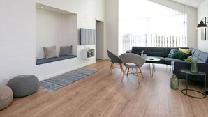 A modern living room with a built-in bench, a sofa, and a dining area. - 5 Star Holiday Home in Lokken (Lokken)