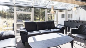 Ett modernt utomhusområde med en soffa, ett bord och ett bordfotbollsspel.
