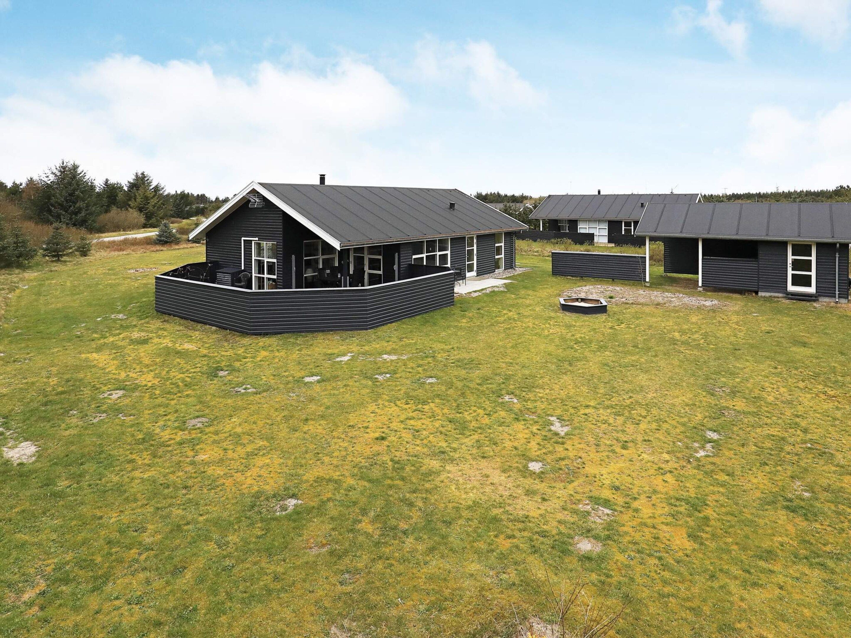 Et moderne boligområde med flere huse, mørke tage og hvide detaljer.