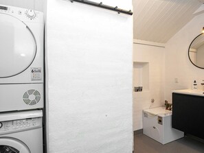 A laundry area with stacked washing machines and a drying rack. - 12 Person Holiday Home in Henne (Henne)