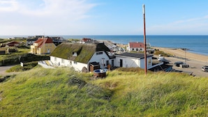 A coastal village with traditional houses, a beach, and a clear view of the sea. - 6 Person Holiday Home in Thisted-by Traum (Thisted)