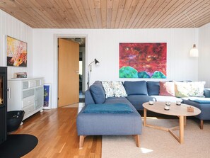 A modern living room with a sectional sofa, a coffee table, and a fireplace.