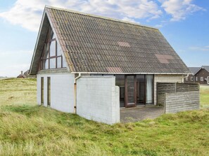 A modern house with a sloped roof, large windows, and a grassy field surrounding it. - Scenic Holiday Home in Harboøre near Sea (Harboore)